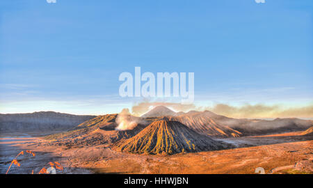 Lever du soleil, le tabagisme Le Mont Bromo, Mt. Batok à l'avant, Mt. Kursi au dos, Mt. Gunung Semeru, Parc National de Bromo Tengger Semeru, Java Banque D'Images