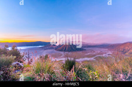 Lever du soleil, le tabagisme Le Mont Bromo, Mt. Batok à l'avant, Mt. Kursi au dos, Mt. Gunung Semeru, Parc National de Bromo Tengger Semeru, Java Banque D'Images