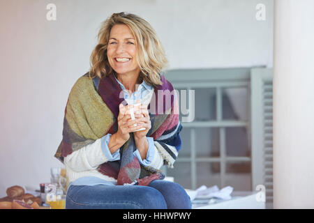 Senior enthousiaste woman drinking coffee on patio Banque D'Images