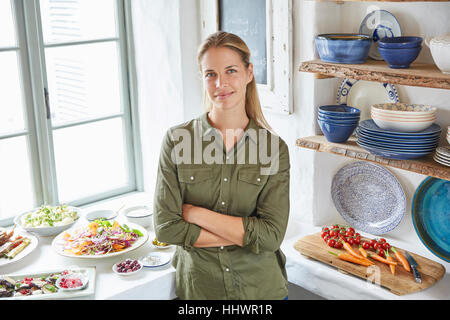 Portrait of smiling woman at table buffet Banque D'Images