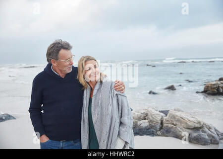 Affectionate couple hugging on winter beach Banque D'Images