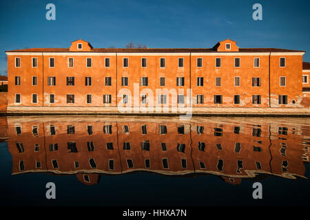 Un bâtiment de l'île de San Servolo reflète dans l'eau de la lagune de Venise. Banque D'Images