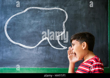 Concept sur tableau noir à l'école. Les jeunes, d'étudiants et d'élèves en classe. Boy crier en classe avec dessin de nuage sur tableau noir. Po Banque D'Images