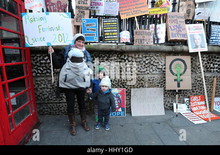 NOTE DU RÉDACTEUR LANGUE SUR PLACARD une femme pose pour une photo de famille en face de banderoles de gauche sur Rue Duncannon, Londres, à la suite d'une marche pour promouvoir les droits des femmes dans le sillage de l'élection américaine. Banque D'Images