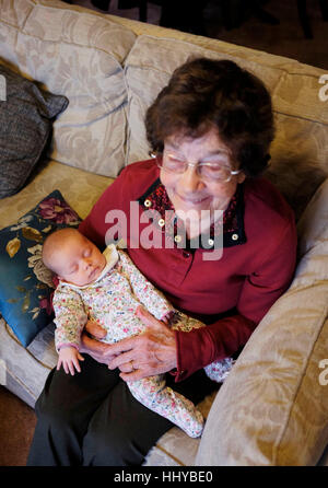 Femme âgée de 80 ans son berçant un bébé fille dans ses bras Banque D'Images