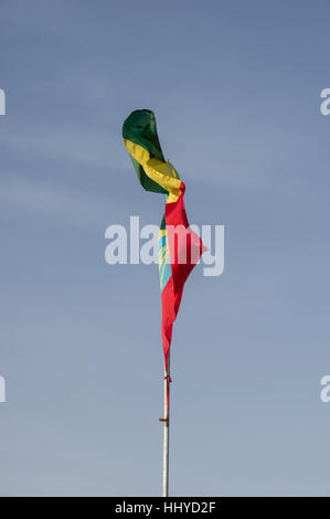 Rouge, jaune et vert du drapeau éthiopien dans le vent avec de l'eau derrière elle Banque D'Images