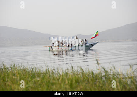 Voile sur le lac de Hawassa, Éthiopie, avec un drapeau de l'Éthiopie, de l'herbe au premier plan, les montagnes en arrière-plan Banque D'Images