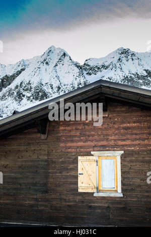 Détail de chalet de montagne avec des montagnes couvertes de neige sur l'arrière-plan. Banque D'Images