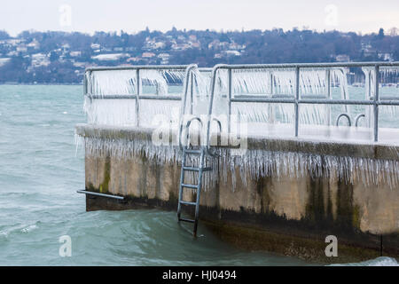 Pier couverte de givre après une tempête hivernale sur le lac de Genève. Banque D'Images