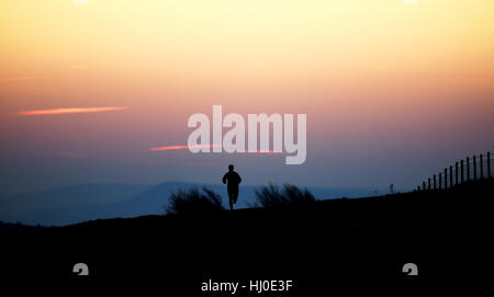 Brighton, UK. 21 Jan, 2017. Un matin tôt runner comme le soleil se lève sur les South Downs Way à Ditchling Beacon juste au nord de Brighton ce matin avec des températures devrait être bien en dessous du point de congélation dans le sud de Bretagne Crédit : Simon Dack/Alamy Live News Banque D'Images