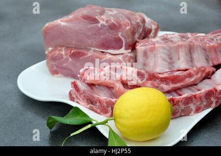 Plateau avec longe de porc, des côtes et un lemon Banque D'Images