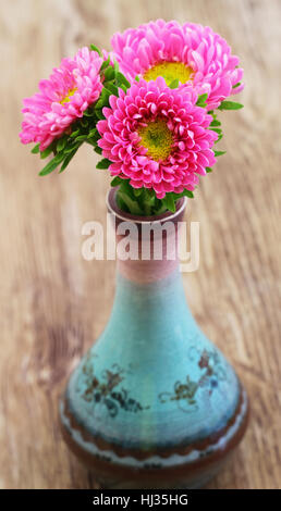 Pink daisies in fine sur la surface en bois vase en porcelaine Banque D'Images