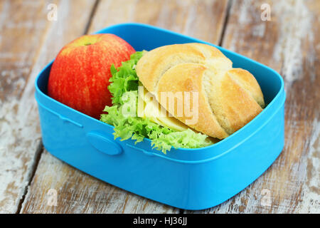 Boîte à lunch sandwich contenant du fromage et pomme rouge sur la surface en bois rustique Banque D'Images