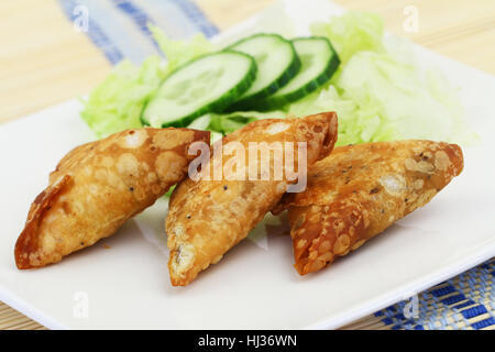 Samosas Indiens trois avec salade verte sur plaque blanche, gros plan Banque D'Images