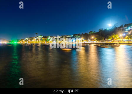 La ville dans le crépuscule du temps avec bateaux et floue lumières de la nuit sur l'arrière-plan. Une longue exposition photo à Buzios, Rio de Janeiro de l'État. Banque D'Images