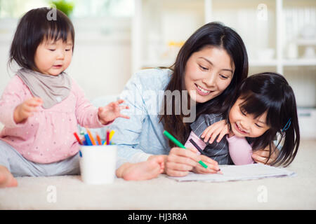 Assez heureux mère japonais jouer avec ses deux mignonnes petites filles à la maison Banque D'Images