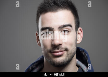 Horizontal Close up portrait of young man wearing non rasé hoodie looking at camera Banque D'Images