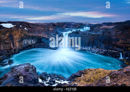 Aldeyjarfoss Falls au lever du soleil montre l'eau sur le bord et les coups d'un nuage de brume sur l'eau. Banque D'Images