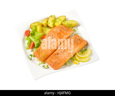 Les filets de saumon avec pommes de terre rôties et garniture de légumes sur la plaque carrée Banque D'Images