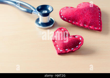 Coeur rouge tissu et stéthoscope sur table en bois - l'état sur l'esprit, l'humeur ou l'état de santé, concept image teinte Banque D'Images