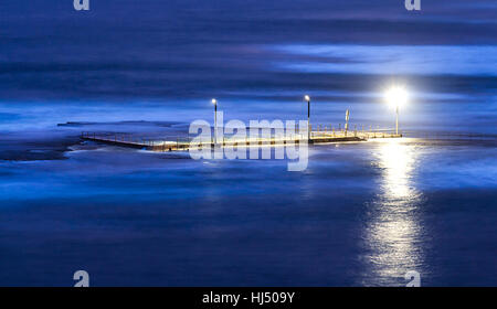 Débranché à marée haute piscine publique à Mona Vale beach à Sydney, Australie. L'illumination de l'électricité sur une perche au-dessus de la surface extérieure survolés Banque D'Images