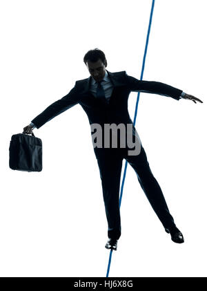 Un caucasian Businessman funambule en silhouette studio isolé sur fond blanc Banque D'Images