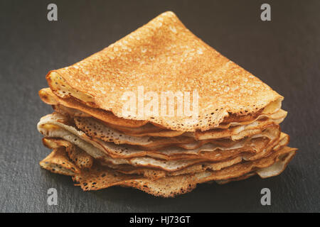 Crêpes minces ou blinis pliée en triangles sur slate board Banque D'Images