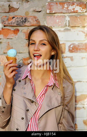 Cool girl avec de la glace près de brick wall Banque D'Images