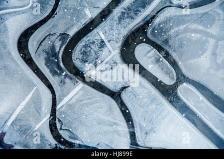 Flaque d'eau gelés en hiver bleu avec des lignes et des courbes noir et blanc nature peinture abstraite Banque D'Images