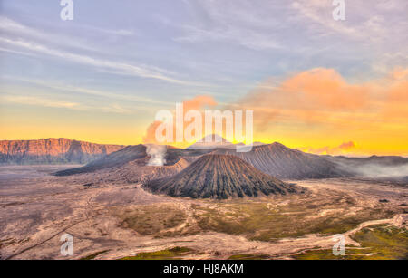 Coucher du soleil, le tabagisme, le Mont Bromo volcan Gunung Batok en face, le Mont Kursi à l'arrière, le Mont Gunung Semeru, Bromo Tengger Semeru Banque D'Images