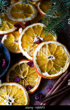 Tranches d'oranges séchées avec des bâtons de cannelle et les branches de sapins Banque D'Images