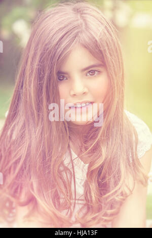 Portrait d'une magnifique petite fille aux cheveux longs, profitant de l'extérieur, de printemps photo style vintage, authentique beauté naturelle d'un enfant, véritable oeil Banque D'Images