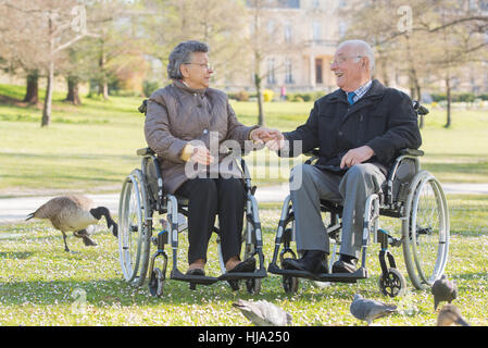 Couple de personnes âgées sur fauteuil roulant Banque D'Images