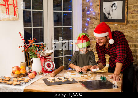 Homme et Fils la préparation de biscuits de Noël au comptoir de la cuisine Banque D'Images