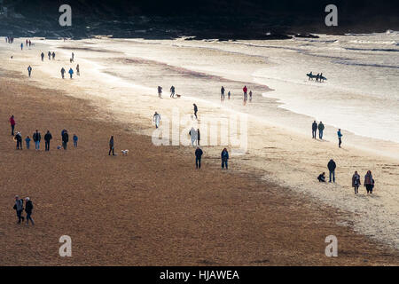 Les gens profiter d'une promenade le long de la plage de Fistral dans la lumière du soir. Banque D'Images