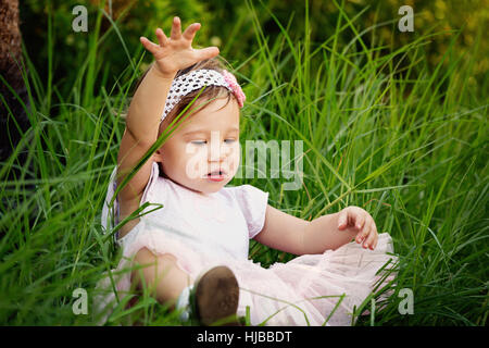 Mignon petit bambin s'amuser dans l'herbe Banque D'Images