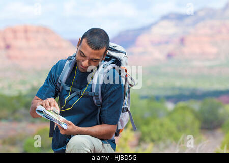 Young male hiker looking at map, Sedona, Arizona, USA Banque D'Images