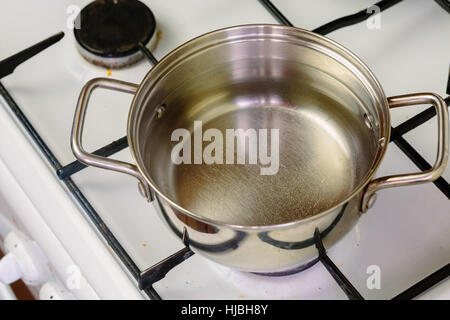 Récipient d'eau bouillante sur la cuisinière à gaz de près. Banque D'Images