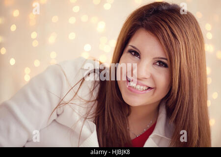 Cute Girl smiling avec des lumières de Noël dans l'arrière-plan Banque D'Images