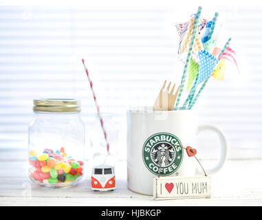 Mug blanc avec logo Starbucks Starbucks , VW camper Van et jelly beans on a white background. Banque D'Images