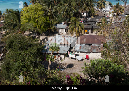 Partie la plus pauvre de l'autre village, maisons simples, la mer d'azur, des palmiers dans l'arrière-plan, journée ensoleillée en octobre, Stonetown, Zanzibar, Tanzania, Africa Banque D'Images