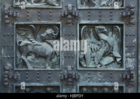 Taureau ailé de Saint Luc et l'aigle de saint Jean. Détail de la porte de bronze de la Basilique de la Santa Cruz (Basilique de la Sainte Croix) dans le Valle de los Caidos (vallée de l'armée déchue) près de Madrid, Espagne. Banque D'Images