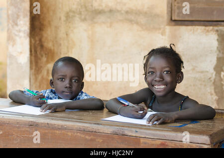 Cute Little Children Learning avec des stylos et du papier en Afrique (symbole de l'enseignement scolaire) Banque D'Images