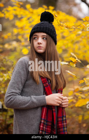 Pretty young girl wearing woolen hat avec couleurs automnales en arrière-plan Banque D'Images