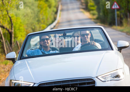 Quatre amis adultes de la conduite sur route rurale en décapotable, Majorque, Espagne Banque D'Images