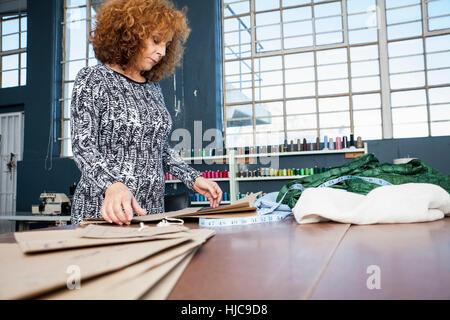 Femelle adulte créateur de mode de préparation sur table d'atelier Banque D'Images