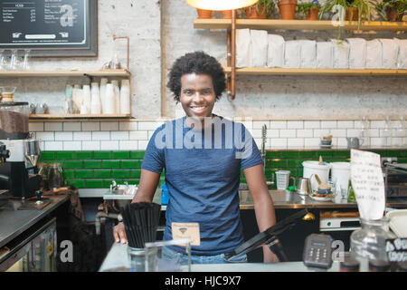 Portrait of young waiter in cafe Banque D'Images