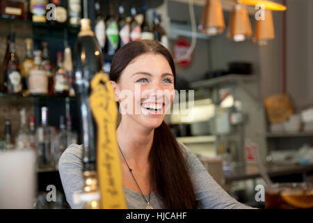 Barman dans un pub servant des boissons, Londres Banque D'Images