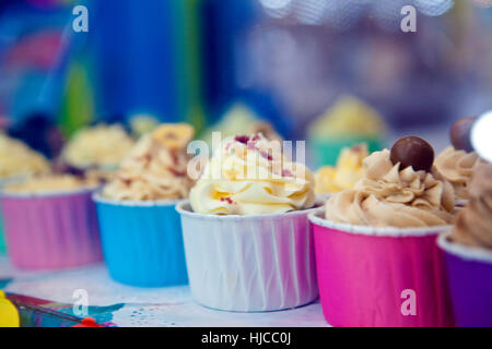 Rangée de cupcakes colorés avec du glaçage en vitrine