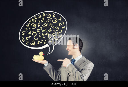 Funny businessman with yellow rubber duck toy Banque D'Images